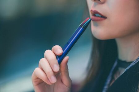 Image of a pretty young woman learning how to use a vessel vape pen.