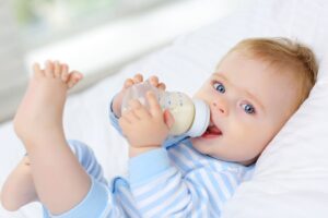 Image of a baby drinking Baby Formula from a bottle.